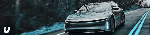 An electric car driving down a road.